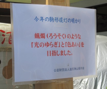 油天神山の駒形提灯についての張り紙 「蝋燭のような『光のゆらぎ』と『色あい』を目指しました。」と書かれている。